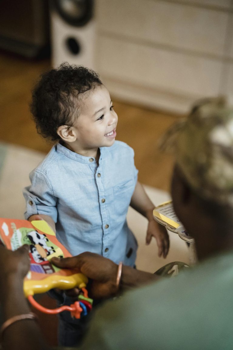 Parents Handing Toys to Smiling Little Boy 